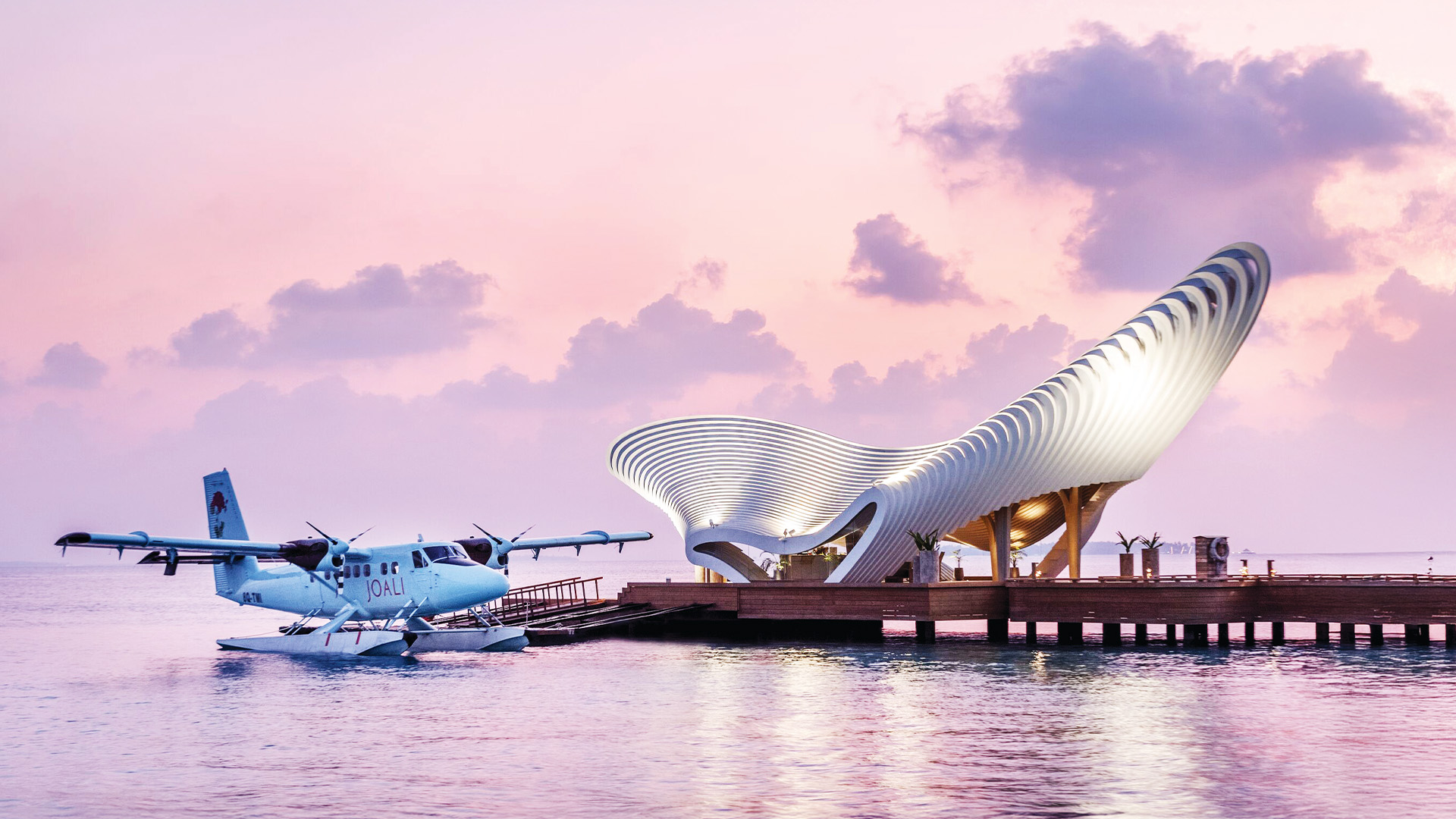view of a plane landing on the water at the elaborate doc of a futuristic resort in the Indian Ocean in the Maldives